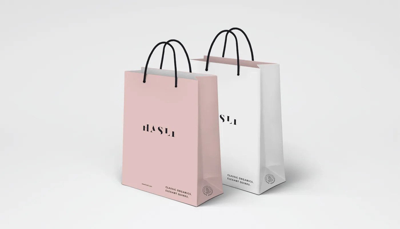 Shopping bags carrying the wordmark, tagline and organic seal.